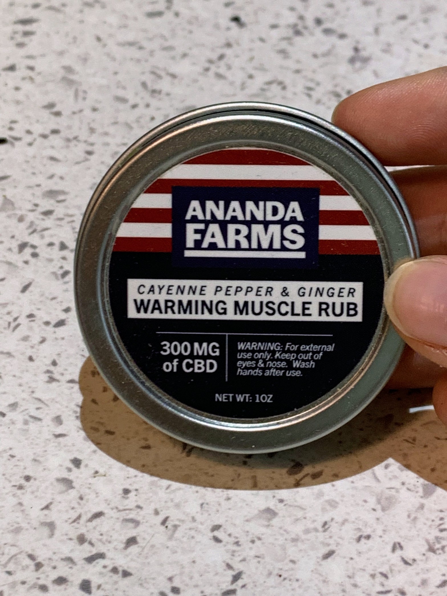 Ananda Farms heating balm on container on white contertop